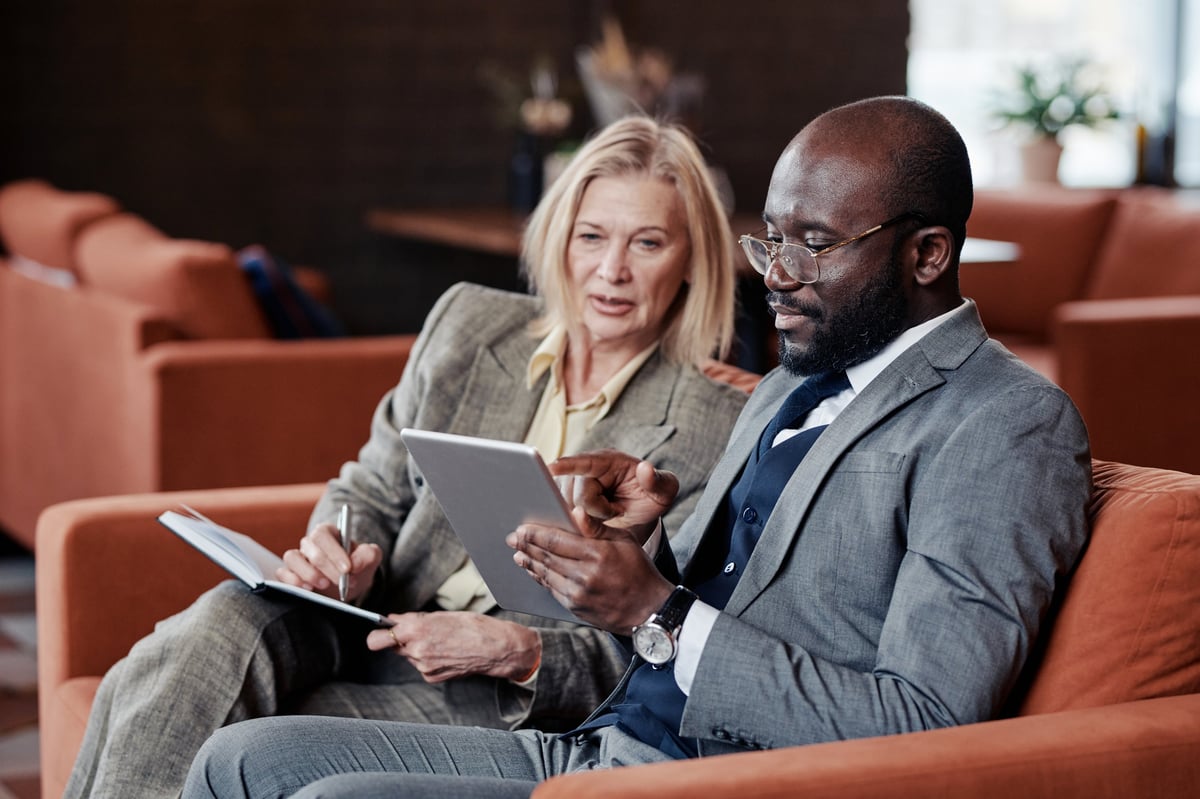 Business partners reviewing strategy on a tablet in a modern cafe