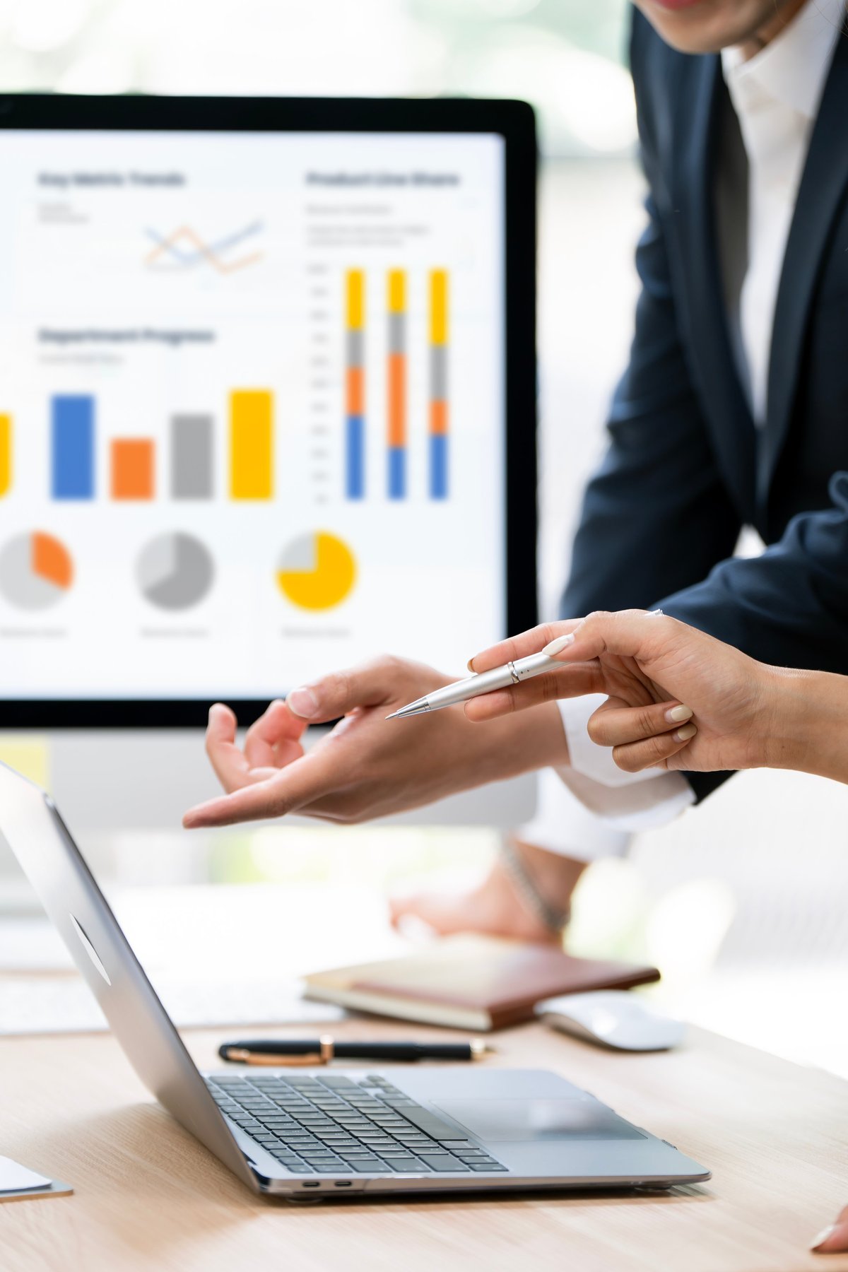Business partners analyzing a financial dashboard and charts on a laptop